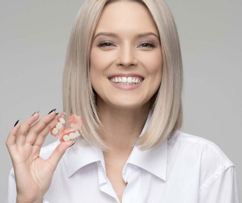 Woman holding partial denture